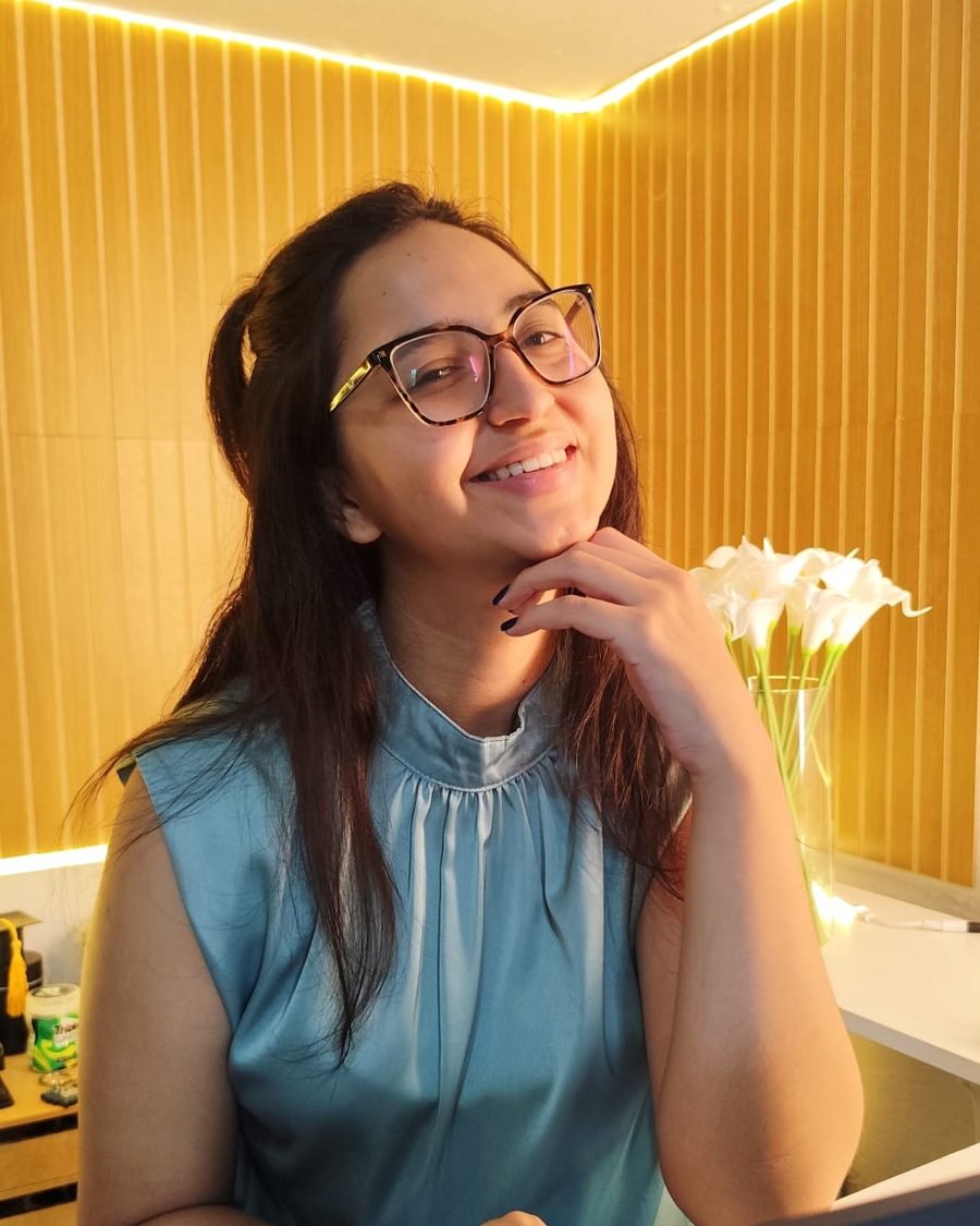 Retrato da psicóloga Brenda Sousa, sorrindo com a mão no queixo